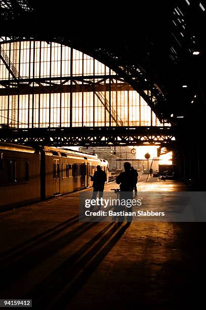 early morning trainstation scene at amsterdam central station - amsterdam sunrise stockfoto's en -beelden