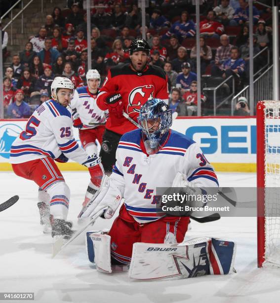 Henrik Lundqvist of the New York Rangers makes the second period save as Patrick Maroon of the New Jersey Devils looks for a rebound at the...