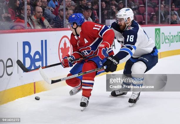 Brendan Gallagher of the Montreal Canadiens fights for the puck against Bryan Little of the Winnipeg Jets in the NHL game at the Bell Centre on April...