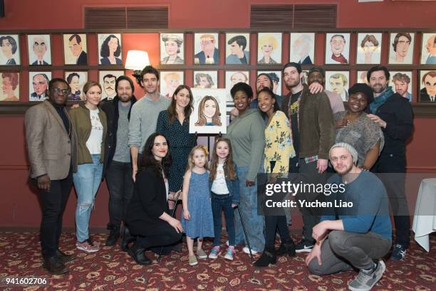 Sara Bareilles standing at left of her caricature with her cast at Sara Bareilles Honored With Sardi's Caricature event at Sardi's on April 3, 2018...