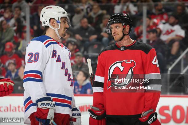 Michael Grabner of the New Jersey Devils and Chris Kreider#20 of the New York Rangers talk on the ice during the game at Prudential Center on April...