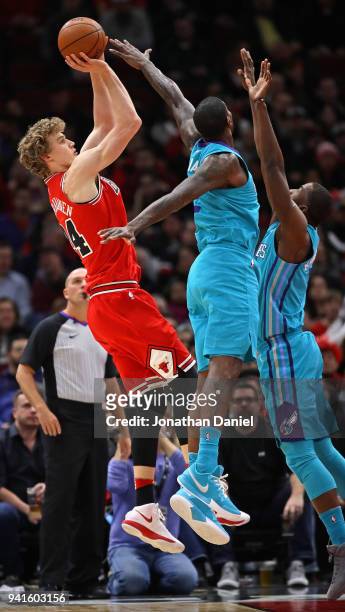 Lauri Markkanen of the Chicago Bulls shoots over Michael Kidd-Gilchrist and Marvin Williams of the Charlotte Hornets at the United Center on April 3,...