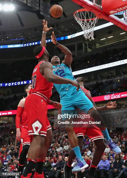 Dwight Howard of the Charlotte Hornets shoots between Noah Vonleh and Bobby Portis of the Chicago Bulls at the United Center on April 3, 2018 in...