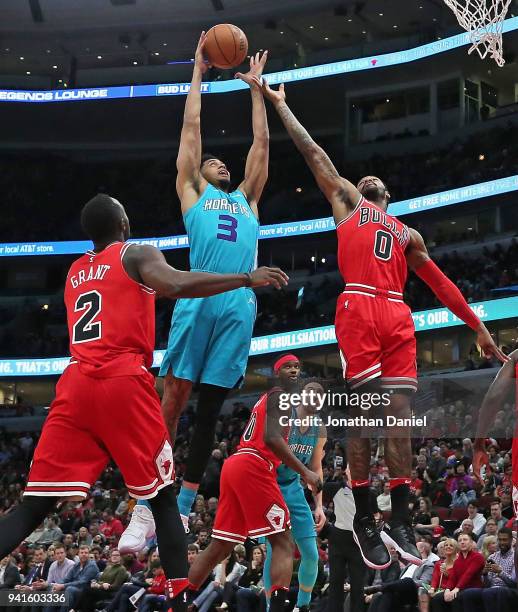 Jeremy Lamb of the Charlotte Hornets rebounds over Jerian Grant and Sean Kilpatrick of the Chicago Bulls at the United Center on April 3, 2018 in...