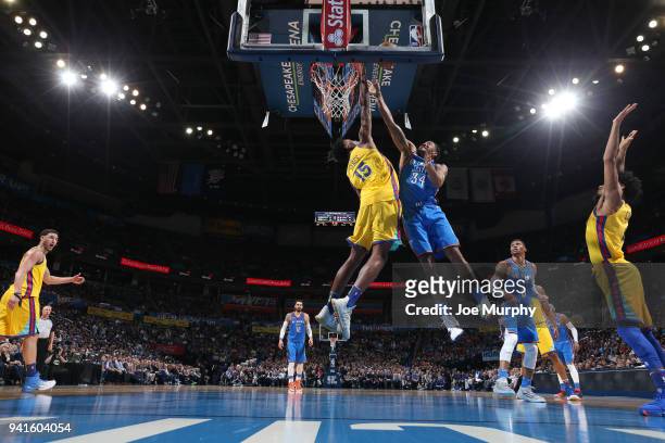 Josh Huestis of the Oklahoma City Thunder drives to the basket during the game against Damian Jones of the Golden State Warriors on April 3, 2018 at...