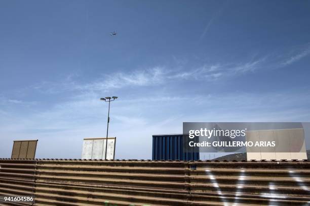 Helicopter overflies US President Donald Trump's border wall prototypes at the US-Mexico border in Tijuana, northwestern Mexico, on April 3, 2018....