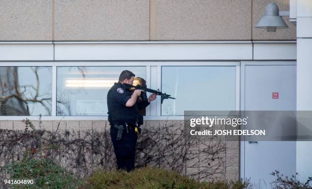 Police officer sweeps a building at YouTube's corporate headquarters where an active shooter situation was underway in San Bruno, California on April...
