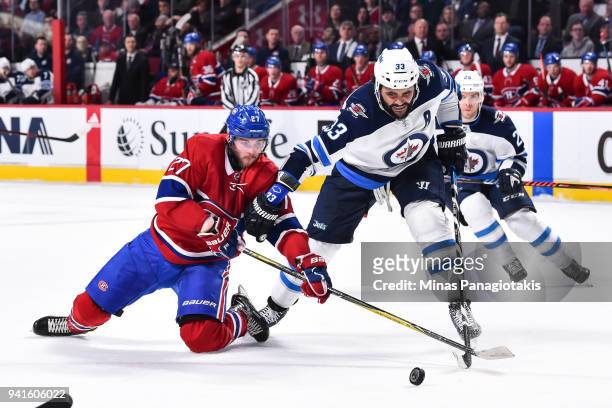 Alex Galchenyuk of the Montreal Canadiens and Dustin Byfuglien of the Winnipeg Jets battle for the puck during the NHL game at the Bell Centre on...