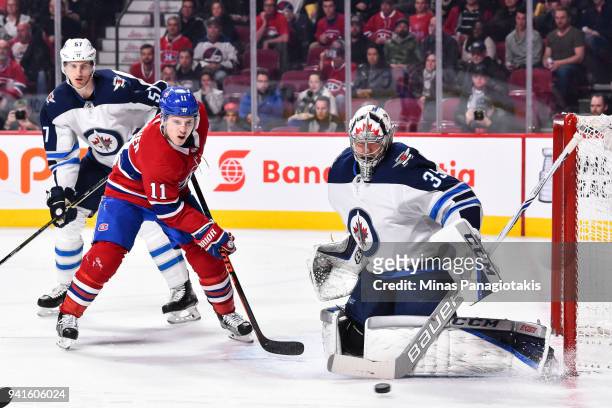 Goaltender Steve Mason of the Winnipeg Jets makes a stick save near Brendan Gallagher of the Montreal Canadiens during the NHL game at the Bell...