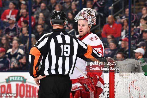 Goaltender Jimmy Howard of the Detroit Red Wings talks with referee Gord Dwyer during the third period of a game against the Columbus Blue Jackets on...
