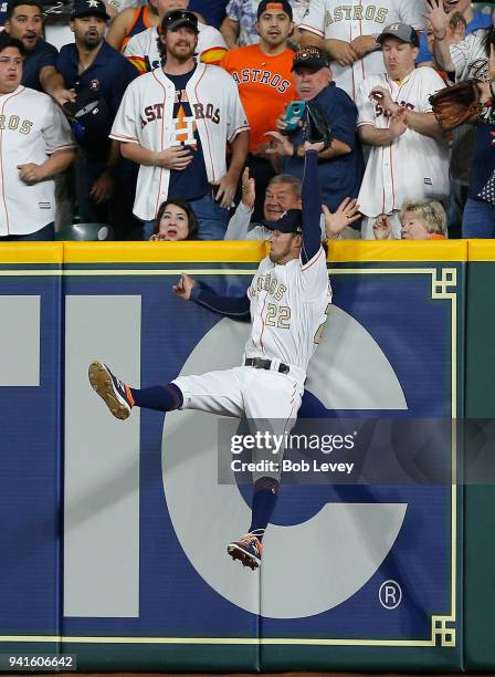 Josh Reddick of the Houston Astros makes a leaping catch at the wall on a fly ball by Trey Mancini of the Baltimore Orioles in the third inning at...