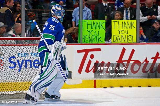 Jacob Markstrom of the Vancouver Canucks looks on as fans hold up signs during warmup before their NHL game against the Vegas Golden Knights at...