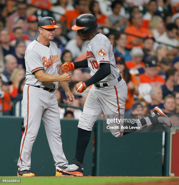 Adam Jones of the Baltimore Orioles receives congratulations from third base coach Bobby Dickerson after hitting a two-run home run in the sixth...