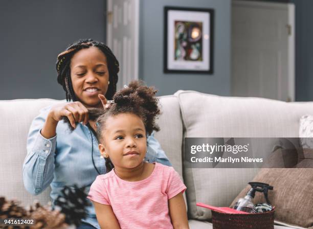 mother styling daugher's hair - marilyn nieves stock pictures, royalty-free photos & images