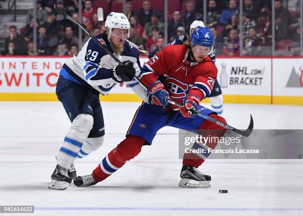 Jacob De La Rose of the Montreal Canadiens passes the puck against pressure from Patrik Laine of the Winnipeg Jets in the NHL game at the Bell Centre...