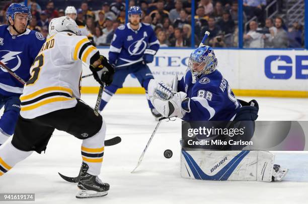 Andrei Vasilevskiy of the Tampa Bay Lightning makes a save as Brad Marchand of the Boston Bruins looks for a rebound during the third period of the...