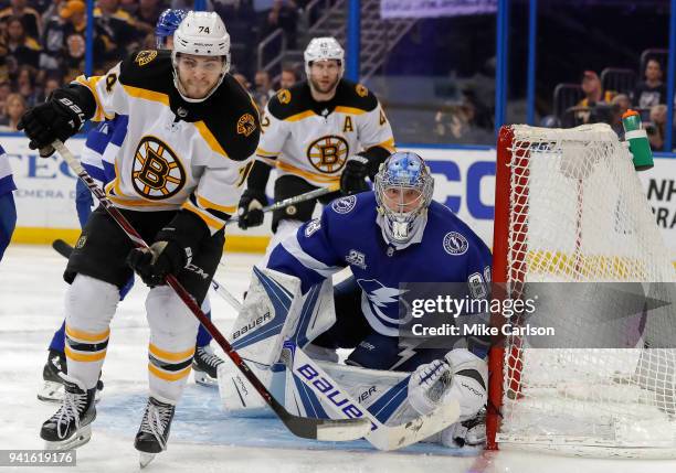 Andrei Vasilevskiy of the Tampa Bay Lightning looks out behind Jake DeBrusk of the Boston Bruins during the third period of the game at the Amalie...