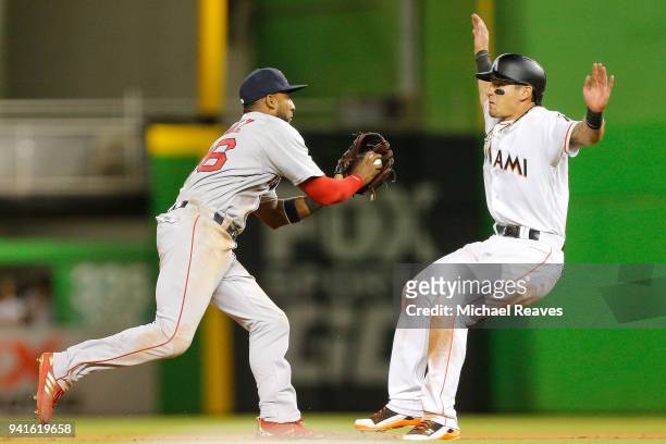 Eduardo Nunez of the Boston Red Sox chases down Derek Dietrich of the Miami Marlins in the thirteenth inning at Marlins Park on April 3, 2018 in...