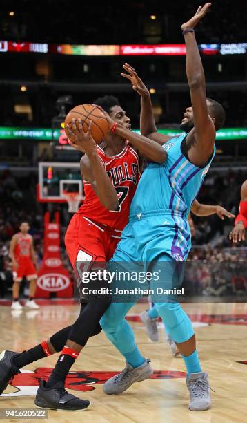 Justin Holiday of the Chicago Bulls is fouled by Michael Kidd-Gilchrist of the Charlotte Hornets at the United Center on April 3, 2018 in Chicago,...