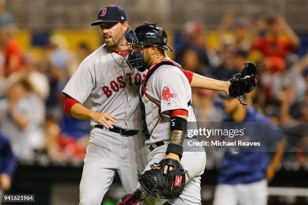 Heath Hembree of the Boston Red Sox celebrates with Christian Vazquez after defeating the Miami Marlins 4-2 in the thirteenth inning at Marlins Park...