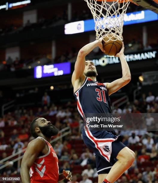Tomas Satoransky of the Washington Wizards goes up for a layup defended by James Harden of the Houston Rockets in the second half at Toyota Center on...