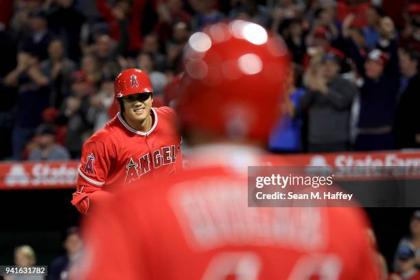 Rene Rivera congratulates Shohei Ohtani of the Los Angeles Angels of Anaheim after his three-run homerun during the first inning of a game against...