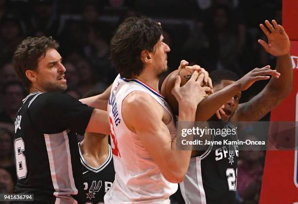 Pau Gasol and Rudy Gay of the San Antonio Spurs defend Boban Marjanovic of the Los Angeles Clippers as he goes for a shot in the first half of the...