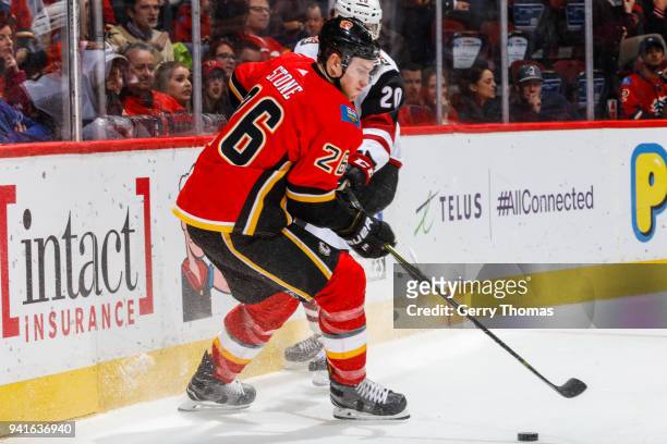 Michael Stone of the Calgary Flames and Dylan Strome of the Arizona Coyotes battle for the puck in an NHL game on April 3, 2018 at the Scotiabank...