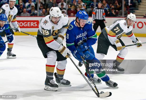 Alex Tuch of the Vegas Golden Knights checks Jake Virtanen of the Vancouver Canucks during their NHL game at Rogers Arena April 3, 2018 in Vancouver,...