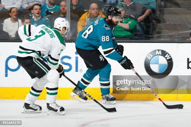 Brent Burns of the San Jose Sharks keeps the puck away from John Klingberg of the Dallas Stars at SAP Center on April 3, 2018 in San Jose, California.