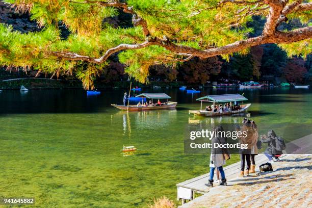 tourists enjoy sightseeing with tourist boats at katsura river, arashiyama - 渡月橋 ストックフォトと画像