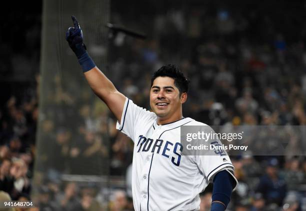 Christian Villanueva of the San Diego Padres comes out of the dugout to wave to the crowd after hitting a three-run home run during the seventh...