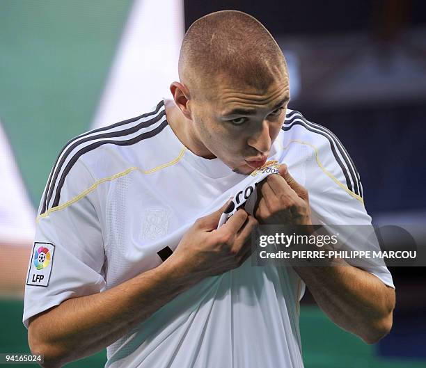 Real Madrid's new football player French Karim Benzema kisses his jersey during his official presentation at the Santiago Bernabeu stadium in Madrid...