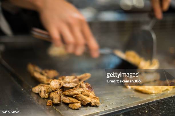 japanese chef cooking beef for client teppanyaki style - teppanyaki stock-fotos und bilder