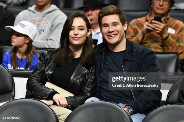 Actors Adam Devine and Chloe Bridges attend a basketball game between the Los Angeles Clippers and the San Antonio Spurs at Staples Center on April...