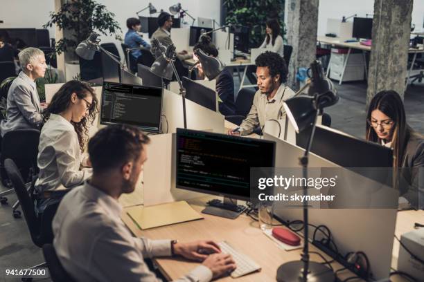 large group of engineers working on computers at corporate office. - large group of people office stock pictures, royalty-free photos & images