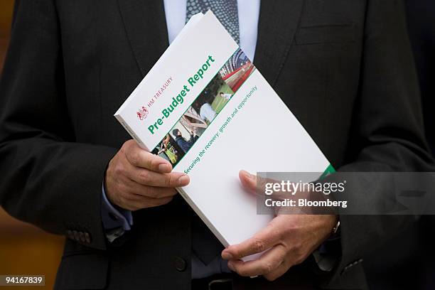 Alistair Darling, U.K., chancellor of the exchequer, holds a copy of the pre-budget on the steps of HM Treasury in London, U.K., on Wednesday, Dec....