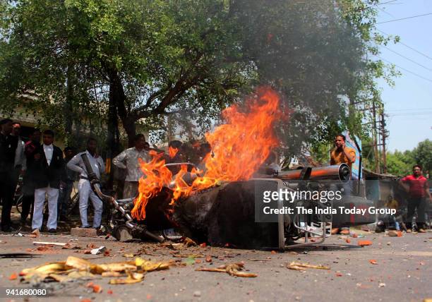Bike set on fire by a group of protesters during 'Bharat Bandh' call given by Dalit organisations against the alleged dilution of Scheduled Castes /...
