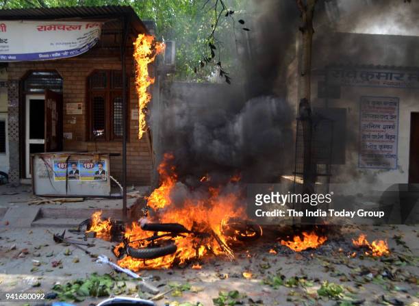 Bike set on fire by a group of protesters during 'Bharat Bandh' call given by Dalit organisations against the alleged dilution of Scheduled Castes /...