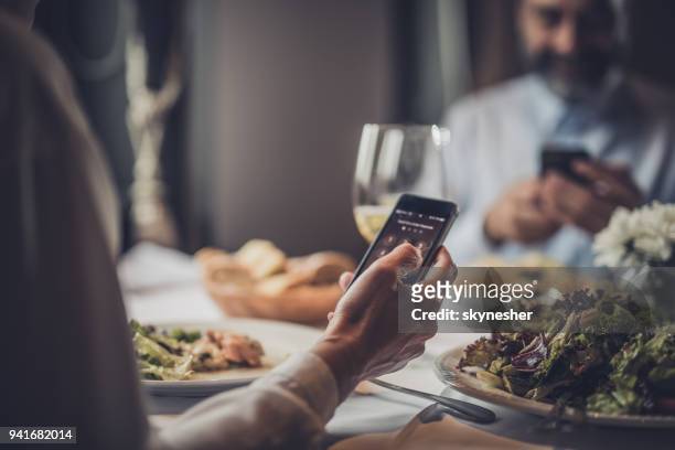primo piano di una donna irriconoscibile che usa il cellulare in un ristorante. - mancanza di rispetto foto e immagini stock