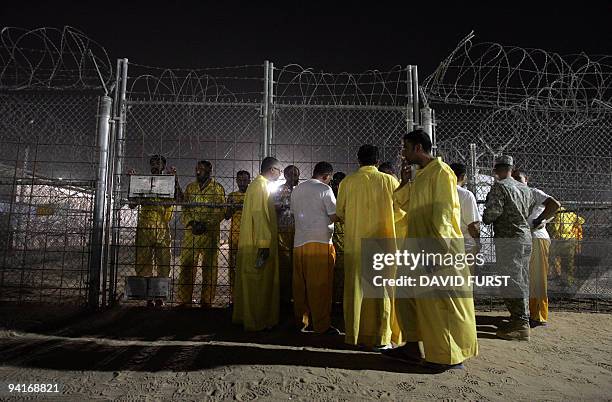 Iraqi detainees talk to one another through a fence inside the Camp Bucca detention centre located near the Kuwait-Iraq border, on May 19, 2008....