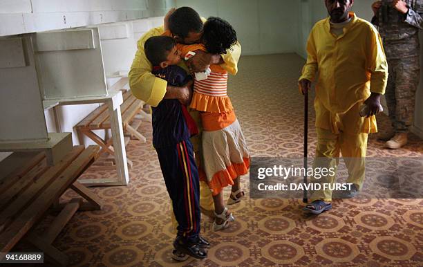 Children of an Iraqi detainee embrace their father during visitation at the Camp Bucca detention centre, located near the Kuwait-Iraq border, on May...