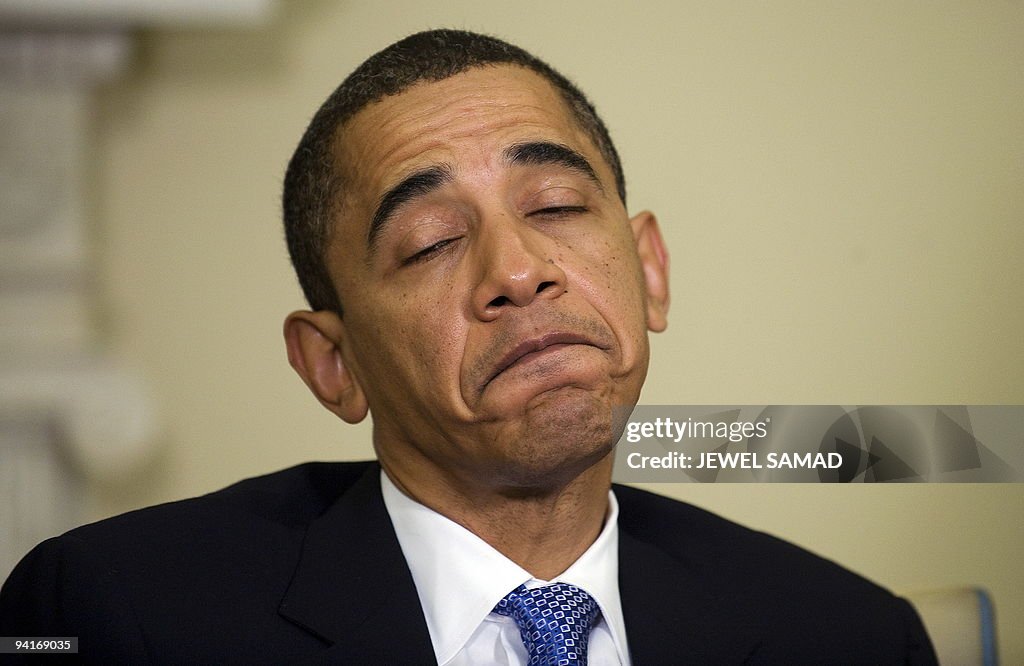 US President Barack Obama grimaces as he