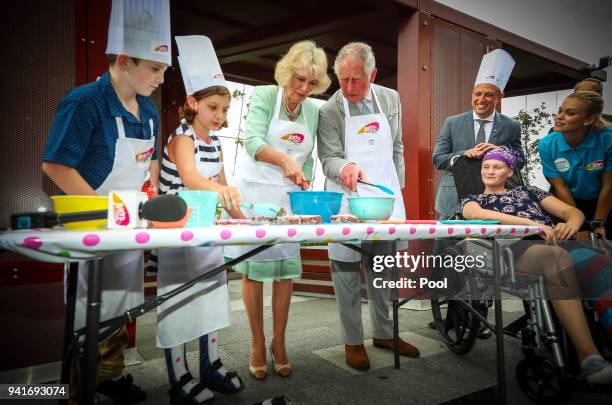 Prince Charles, Prince of Wales and Camilla, Duchess of Cornwall help prepare lamingtons with Elizabeth Ross - 9 and Max Bishop - 12 during an...