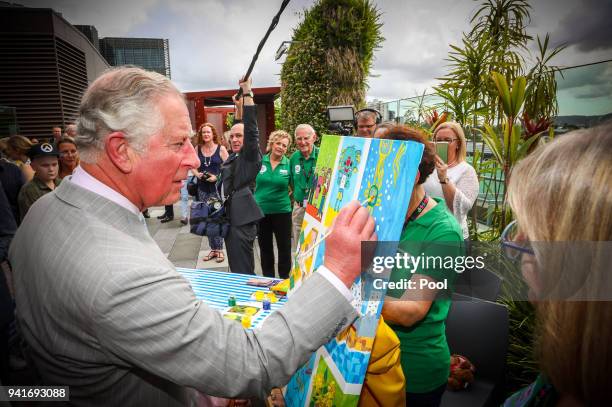 Prince Charles, Prince of Wales adds his finishing touch to a children's painting during his official visit to the Lady Cilento Children's Hospital...