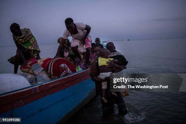 Congolese refugees exit a boat after landing in Sebagoro, Uganda on March 23, 2018. Violence in Ituri Province in northeastern Democratic Republic of...