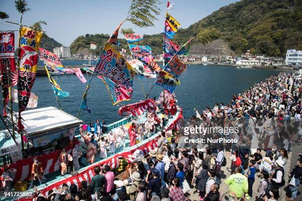 Boat load of dancing fishermen with their faces powdered white and dressed with women's robes took center stage at the Uchiura fishing port during...