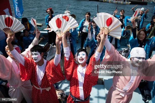 Boat load of dancing fishermen with their faces powdered white and dressed with women's robes took center stage at the Uchiura fishing port during...