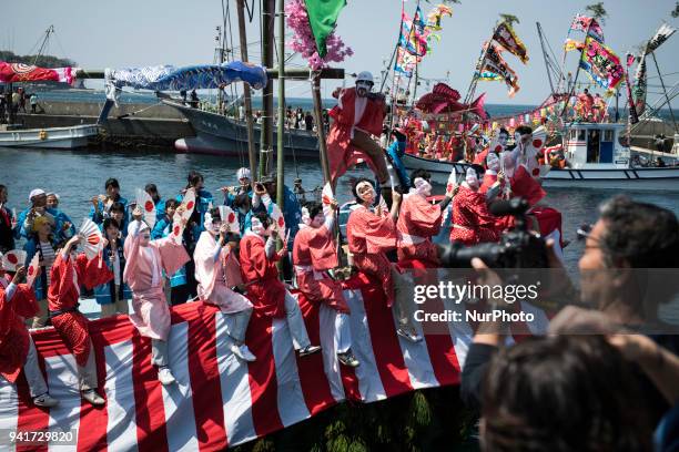 Boat load of dancing fishermen with their faces powdered white and dressed with women's robes took center stage at the Uchiura fishing port during...