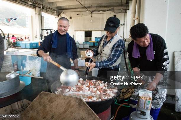 Residents of the village serve a freshly cook seafood soup to the festival goers during the Ose Matsuri/festival held at Uchiura fishing port in the...
